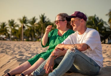 Couple sitting together on the beach during a family photoshoot at Mövenpick Resort Phu Quoc