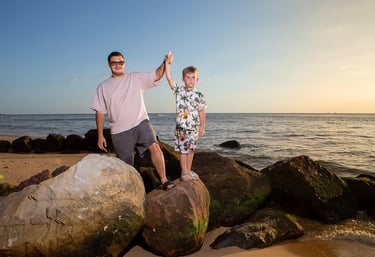 Папа и сын стоят на камнях на пляже Radisson Blu Resort