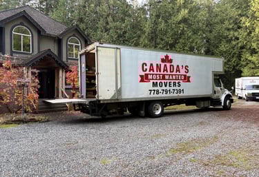 Canada’s Most Wanted Movers truck parked at a forest-side home in the Lower Mainland during a residential move.