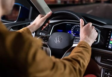 Bild eines Studenten am Steuer eines VW-Autos, der Fahrunterricht erhält oder übt.