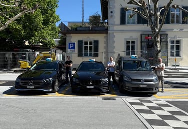 Three taxicars. One grey VW Caddy and two black Mercedes E-Classes with taxidrivers.
