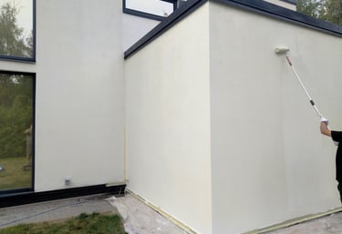 Un technicien expert de chez Oxoclean applique une protection hydrofuge sur une façade d'une maison