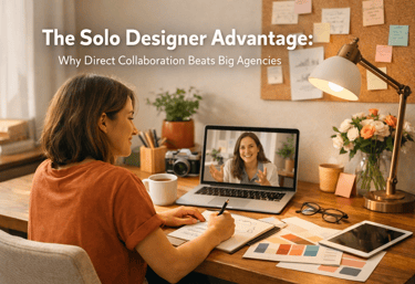 Solo graphic designer working at a desk while collaborating via video call on a laptop.
