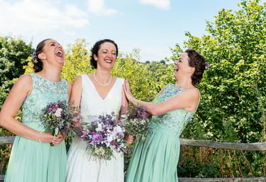 a bride and bridesmaid laughing together