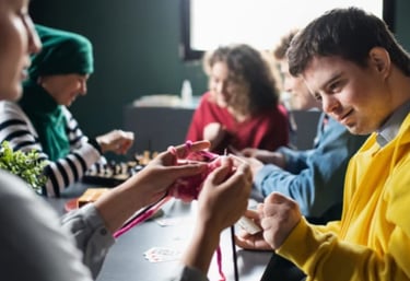 NDIS participants and support workers engaging in a group arts and crafts activity