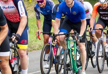 a group of cyclists riding bikes on a road