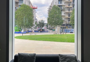 View from a window with window seat overlooking the park and other tall buildings 