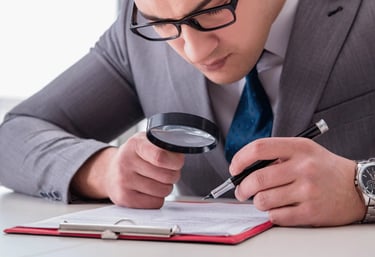 homem com uma lupa inspecionando um documento