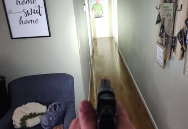 Individual using a personal firearm and self-defense tactics during home defense training.