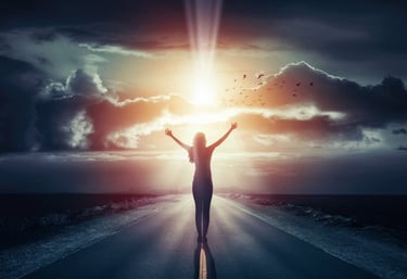 a young woman standing on a road with their arms up in the air