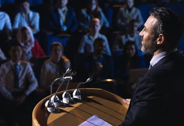 a man in a suit and tie is standing at a podium with microphones