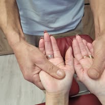 A physical therapist performs a therapeutic hand and palm massage to relieve tension.