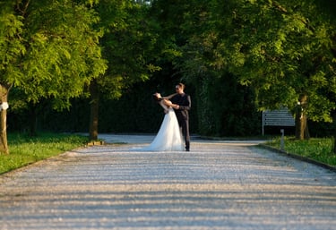 a bride and groom are standing in a park