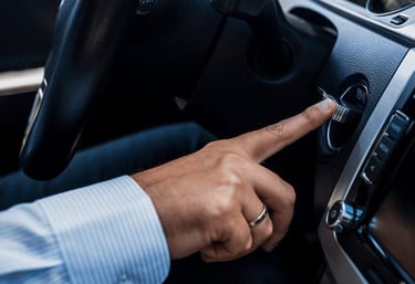 a man's hand is pressing a button on a car