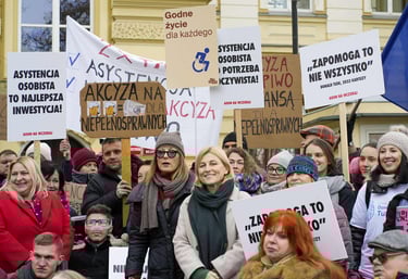 Tłum osób z transparentami. Zdjęcie z Protestu o Ustawę o asystencję osobistą przed KPRM.