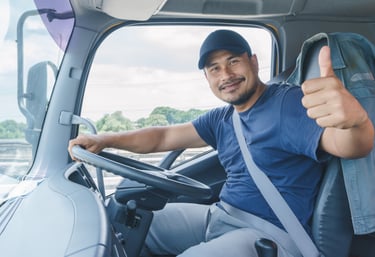 a man in a blue shirt is sitting in a truck