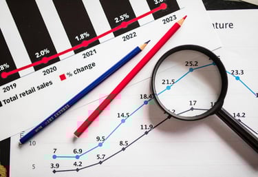 magnifying glass highlighting investing chart symbolizing gold market for precious metals