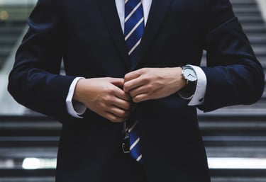 gold ira company worker with suit on in front of stairs representing choosing the right gold ira company