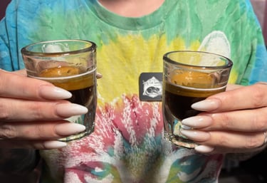 Hands holding two espresso shots