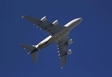 An Etihad Airways passenger airplane flying overhead in the sky
