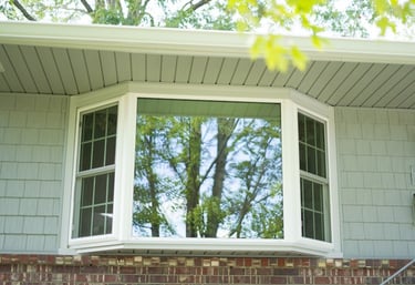 a bay and bow window that extends past the outside wall of the front of the house
