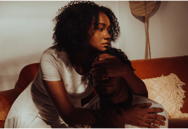 a woman sitting on a couch comforting a friend