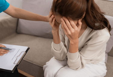 a woman in a white dress sitting on a couch