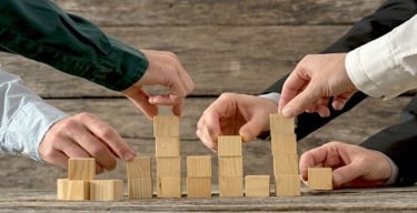 Construccion de bloques de madera simbolizando trabajo en equipo.
