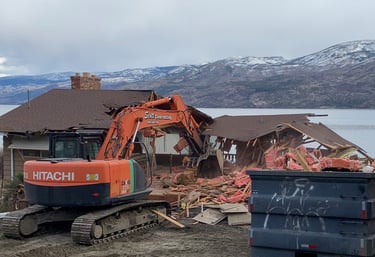 excavator demolishing a residential structure