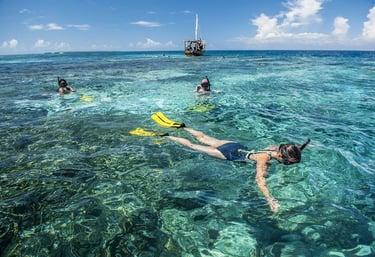 Someone snokelling in Mnemba Island, clear blue water