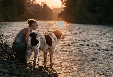 donna e cane al tramonto sul fiume