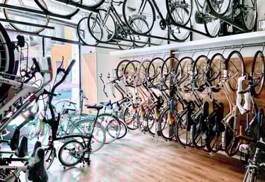 a room with many bikes and bicycles parked in front of a store