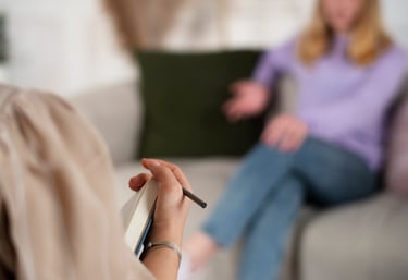 a woman sitting on a couch with a pen in her hand