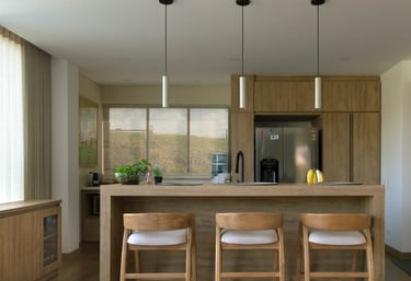Cocina moderna remodelada en madera clara con isla central, mostrando resultado de proyecto de remod