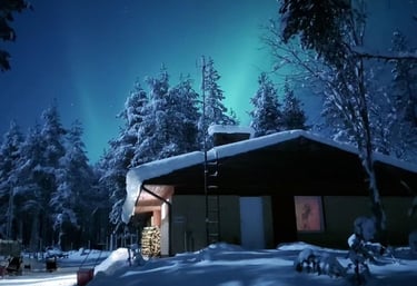 Chalet enneigé en Laponie avec des aurores boréales illuminant, le ciel nocturne et des arbres