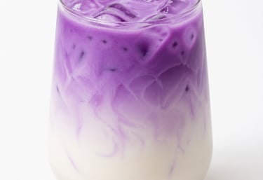 Layered iced ube latte with purple yam swirl and milk in a glass over a white background.