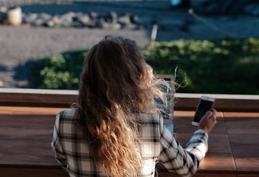 a woman sitting on a bench looking at her cell phone