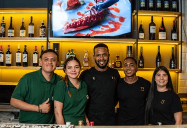 Equipo del restaurante trabajando en barra, personal profesional y cercano en un ambiente acogedor.