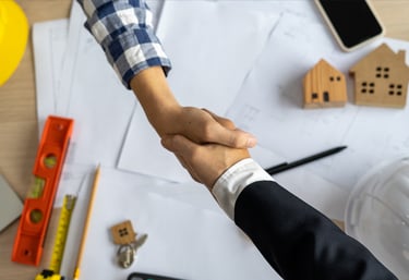 a man and woman shaking hands over a table