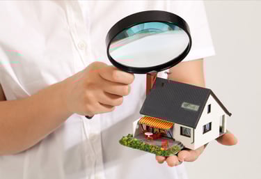 a person holding a magnifying magnifying a house