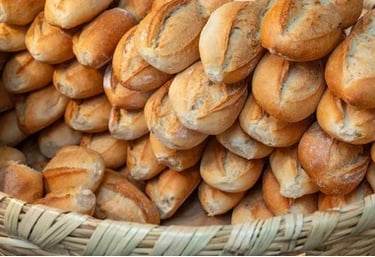 Una canasta tejida rebosante de panecillos artesanales recién horneados, de corteza crujiente,