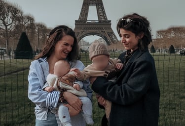Deux femmes heureuses tenant des bébés pendant des vacances en famille devant la Tour Eiffel à Paris