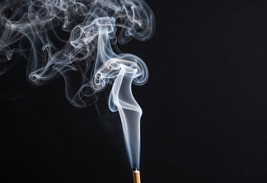A column of thick mist white incense smoke rising vertically against a solid charcoal black background.