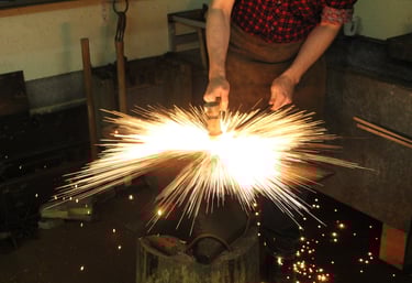 Professional blacksmith at Eitri Forge shaping glowing orange steel on an anvil