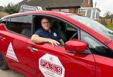 Professional instructor in a red car for automatic driving lessons at Jason's Driving School.