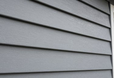 A detail shot of high-quality mist grey siding and plastic texture finishes on a residential facade in South America / Latin America. Sharp focus on the craftsmanship.