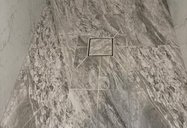 Modern walk-in shower featuring envolpe cut porcelain tiles for base.
