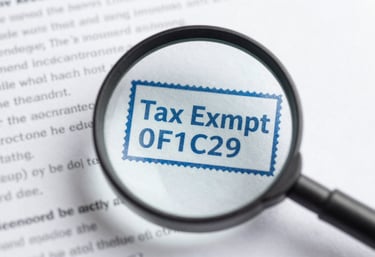 A magnifying glass focusing on a 'Tax Exempt' stamp on a document, illustrating clarity and professional oversight in #B6DDE5 and #0F1C2E.