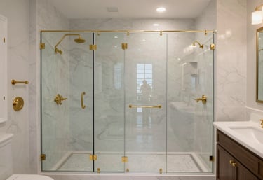 A wide shot of a luxury bathroom remodel featuring a glass shower and amber gold fixtures in a North American / US (Dallas-Fort Worth) residence.