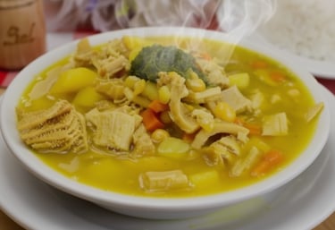 a bowl of soup with vegetables and rice